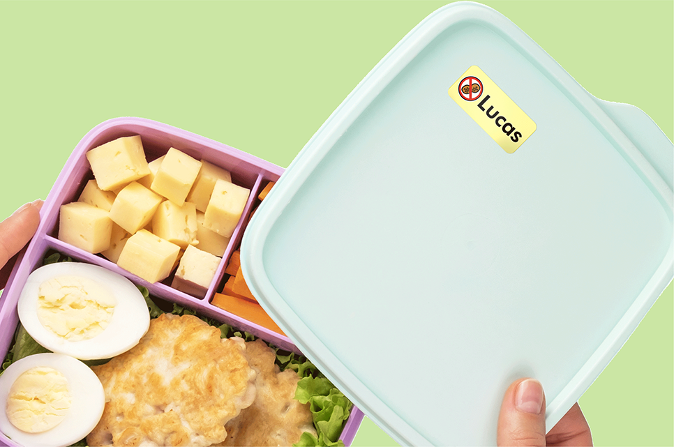 Lunchbox met een notenallergie-label, deels open met eten erin
