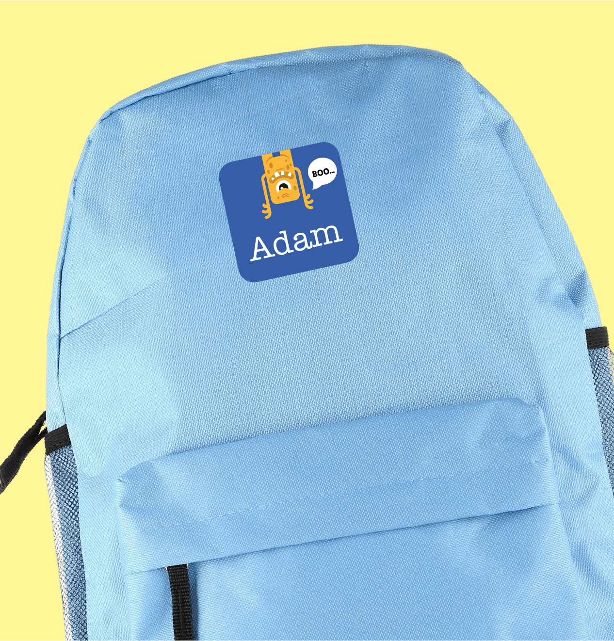 Lichtblauwe rugzak met een grote gepersonaliseerde sticker met een getekend monstertje en naam
