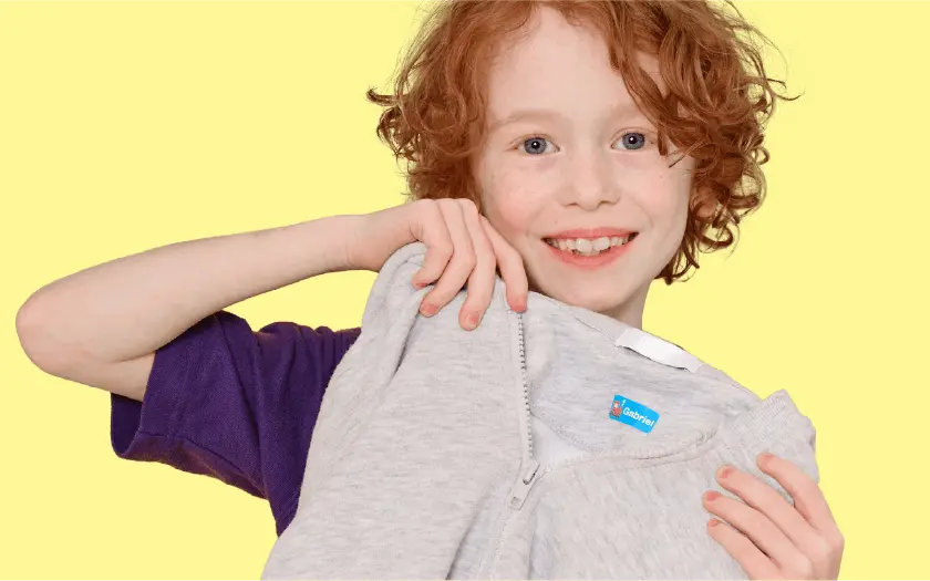 Jongen die een trui met strijklabel omhooghoudt